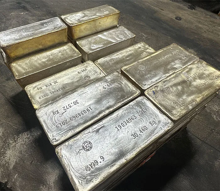 Large cast silver bars stamped with serial numbers and weights, stacked on a pallet